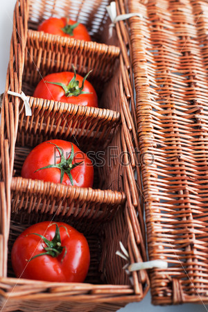 Four tomatoes lying separately in wicker box