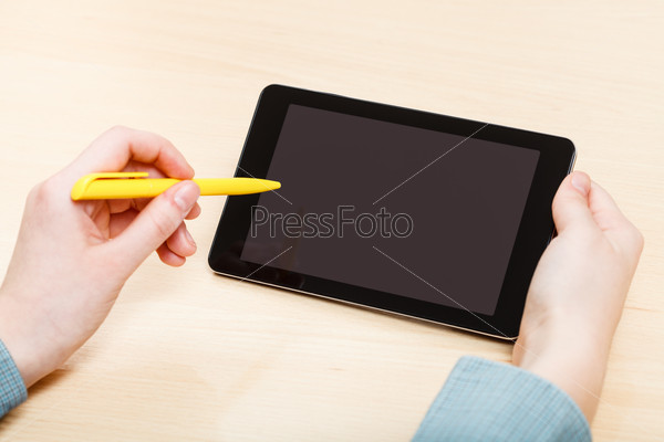 businessman touches by pen of tablet PC with black screen at office table