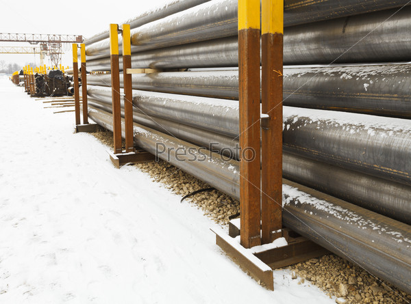 Stacks of construction pipes on outdoor warehouse