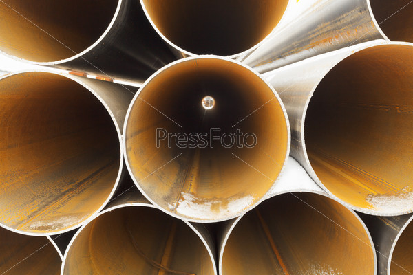 Tops of rusty pipes close up on outdoor warehouse in winter, stock photo