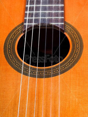 sound hole of spanish acoustic guitar with six nylon strings close up