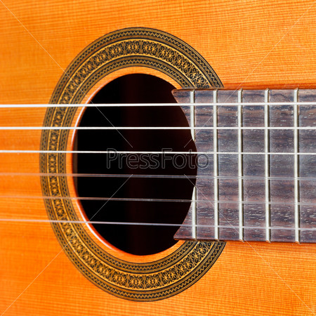 fretboard and sound hole of classical acoustic guitar with six nylon strings close up