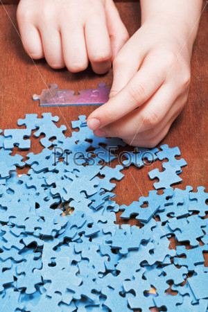 assembling of jigsaw puzzles on wooden table