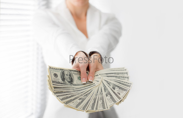 Portrait of a happy woman with a fan of american dollar currency notes