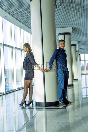 Young couple standing with his back to the column