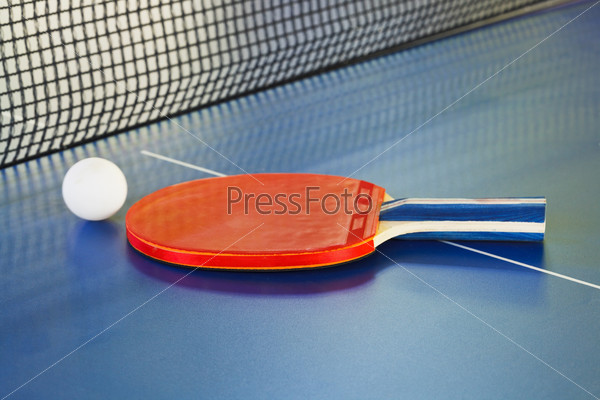 red paddle, tennis ball on ping pong sport table close up