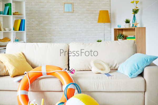 Sofa in empty room with equipment and accessories for travel on it