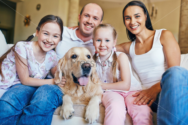 Friendly family with dog having rest at home