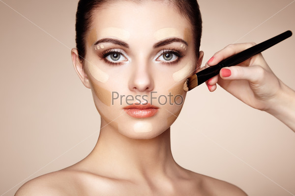 Makeup artist applies skintone. Beautiful woman face. Perfect makeup. Skincare foundation