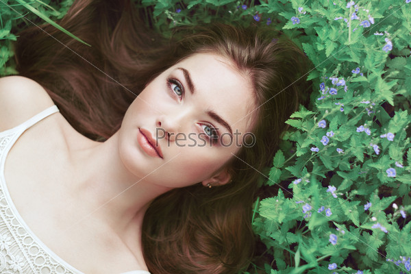 Portrait of a beautiful young woman in summer garden. Girl on nature. Spring flowers. Fashion beauty, stock photo