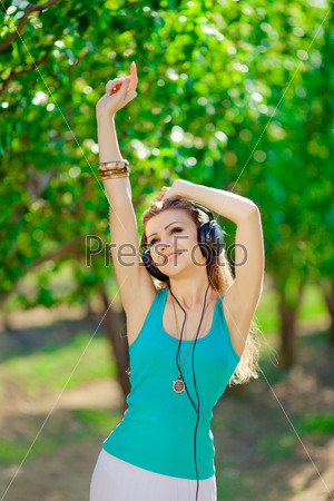 Beautiful young woman listen to music wearing headphones outdoor