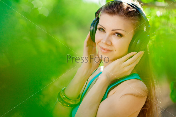 Beautiful young woman listen to music wearing headphones outdoor