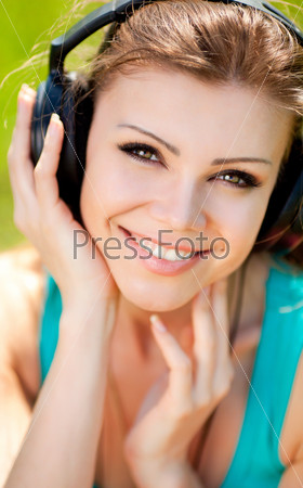 Beautiful young woman listen to music wearing headphones outdoors