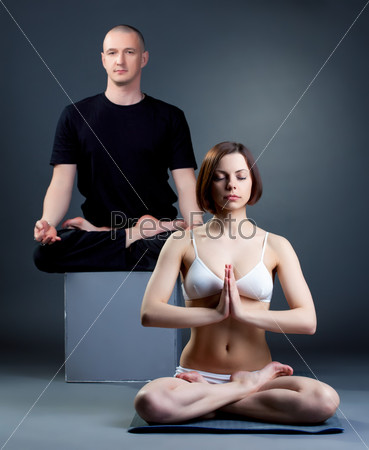 Meditating yoga trainers posing in studio