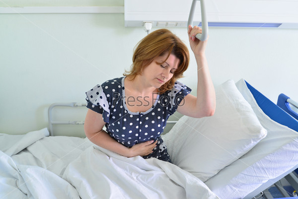 Female patient holding on to a device for lifting in hospital room