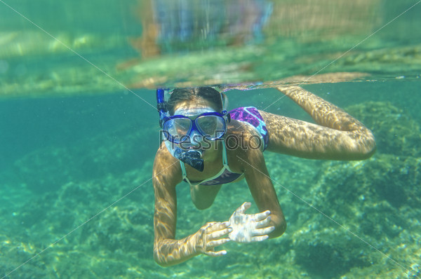 Underwater shoot of a cute girl snorkeling in a tropical sea