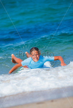 Teenage girl in blue learning to surf