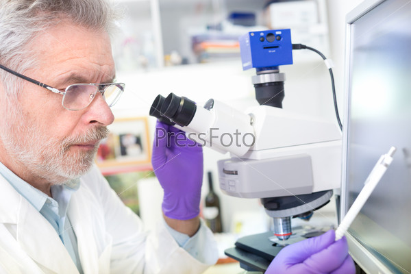 Senior scientist microscoping in lab.