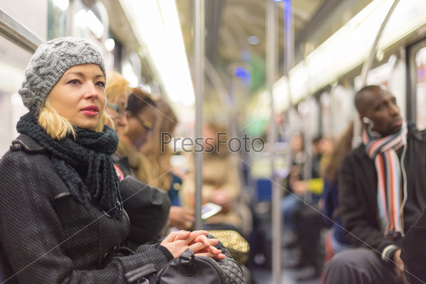 Woman traveling by subway full of people.