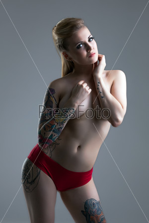 Busty tattooed girl posing in red panties