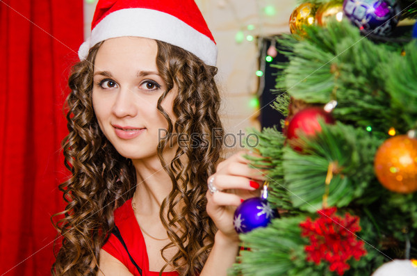young girl dresses up Christmas tree