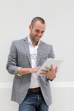 Cool businessman using electronic tablet