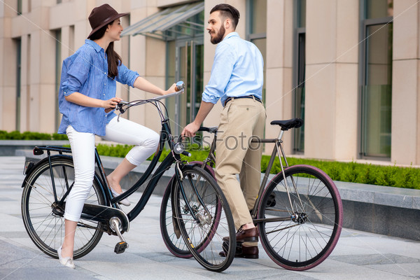 Romantic date of young couple on bicycles at street