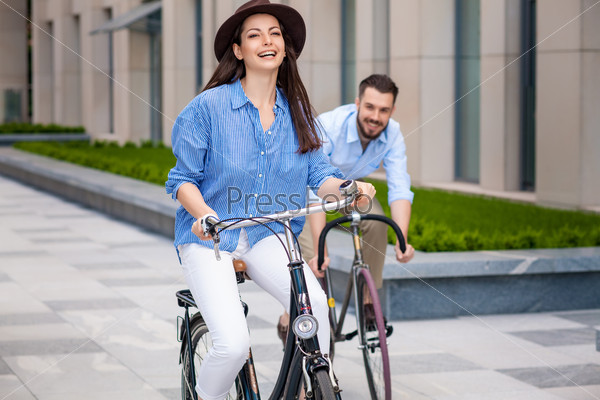 Romantic date of young couple on bicycles at street, stock photo