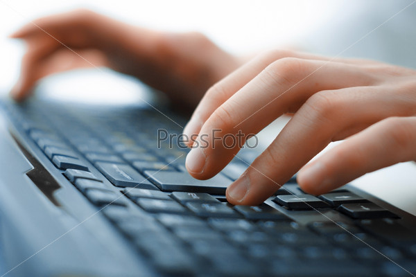 Close-up of typing hands on keyboard, stock photo