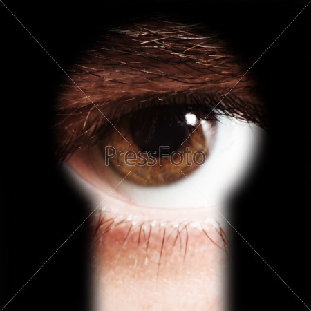 Scared male eye spying through a keyhole