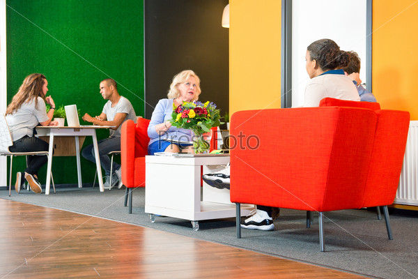 Several people sitting in a business lounge during informal meetings and project team conferences