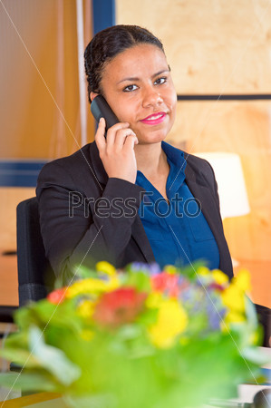 Young receptionist of a large cooperation taking calls on a phone