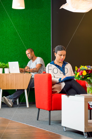 Luxurious corporate lounge, with two people working quietly and comfortably