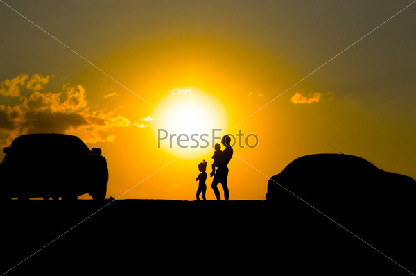 happy family of three people,celebrate outside at Sunset, Silhouette against the evening sky