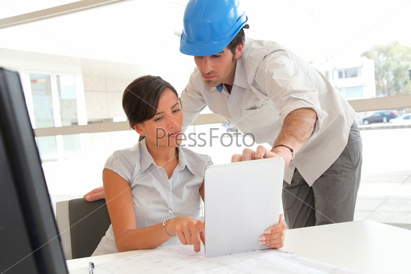 Architects working in office with electronic tablet