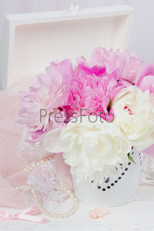 Still-life with a bouquet of peonies and pink veil and lace