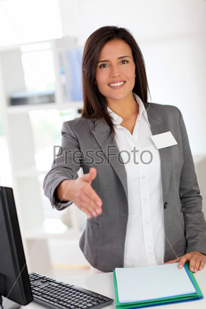 Portrait of beautiful smiling hostess giving handshake