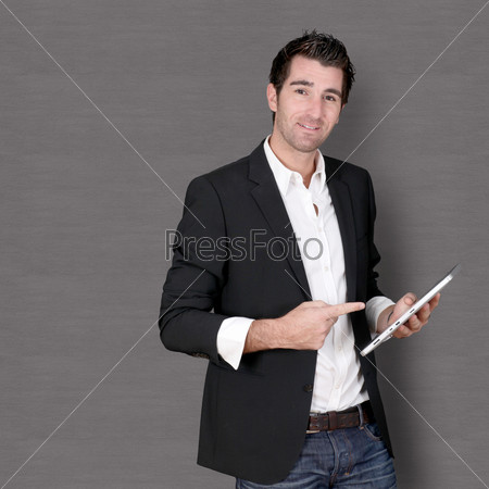 Smiling man standing on dark background, stock photo