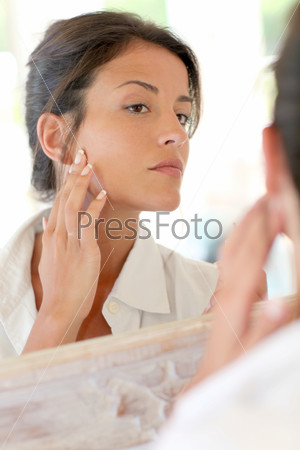 Portrait of woman applying foundation makeup on her face
