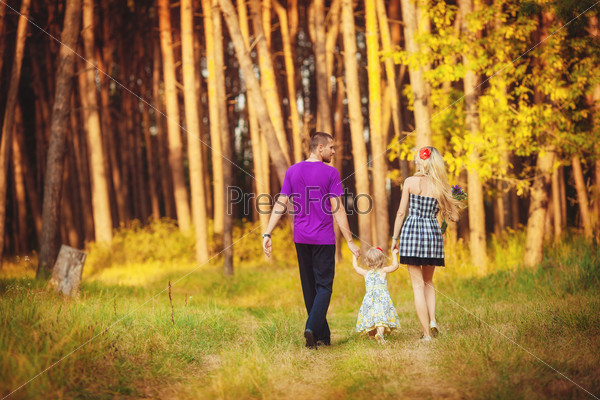 Молодая семья на прогулке в лесу