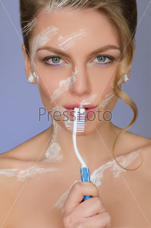 woman with toothbrush and toothpaste on body