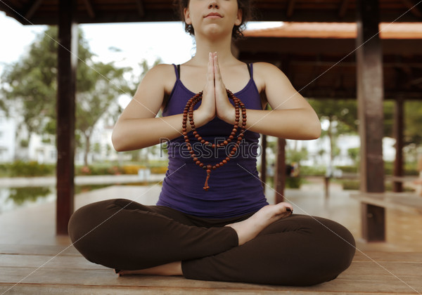 Meditating woman with rosary in her hands: spirituality concept
