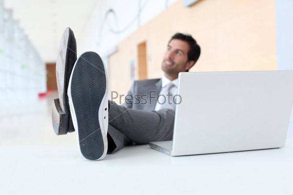 Businessman relaxing wih feet on desk