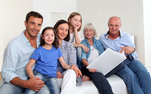 3-generation family looking at photo album, stock photo
