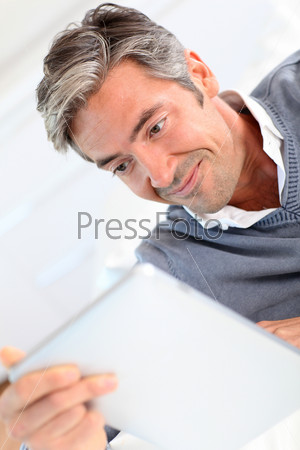 40-year-old man at home using electronic tablet
