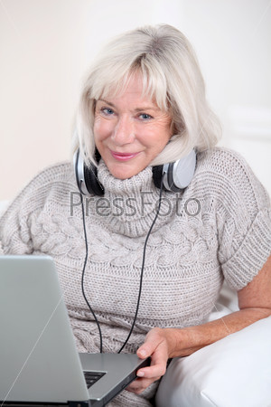 Senior woman listening to music with headphones