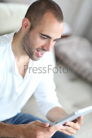 Closeup of handsome man web surfing on touchpad