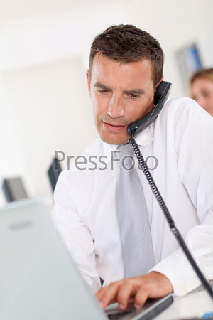 Office worker talking on the phone in office