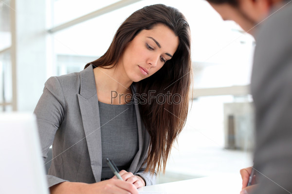 Businesswoman writing on document after meeting