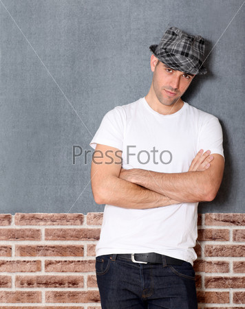 Trendy guy with arms crossed on urban background